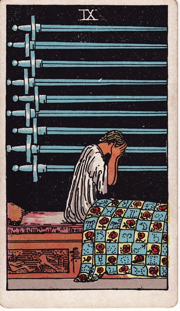 Tarotkortet Nio i svärd – en person sitter upp i sängen i ångest – symboliserar oro, insomnia och mentalt lidande.