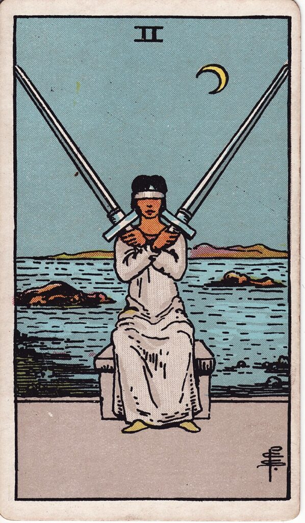 Tarotkortet Två i svärd – en blind kvinna håller två korslagda svärd vid havet – representerar beslutsångest, balans och att inte vilja se sanningen.